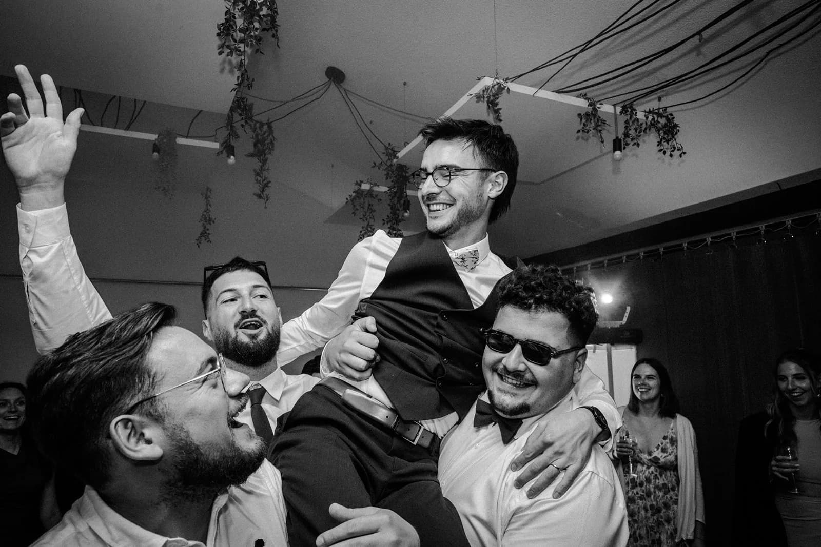 Gabriel porté par ses amis sur le dancefloor en noir et blanc